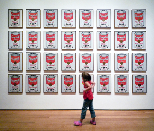 Girl Looking at Andy Warhol, Campbell's Soup Cans, 1962, synthetic polymer paint on 32 canvases, each 20 x 16 inches (The Museum of Modern Art) (photo: Steven Zucker)